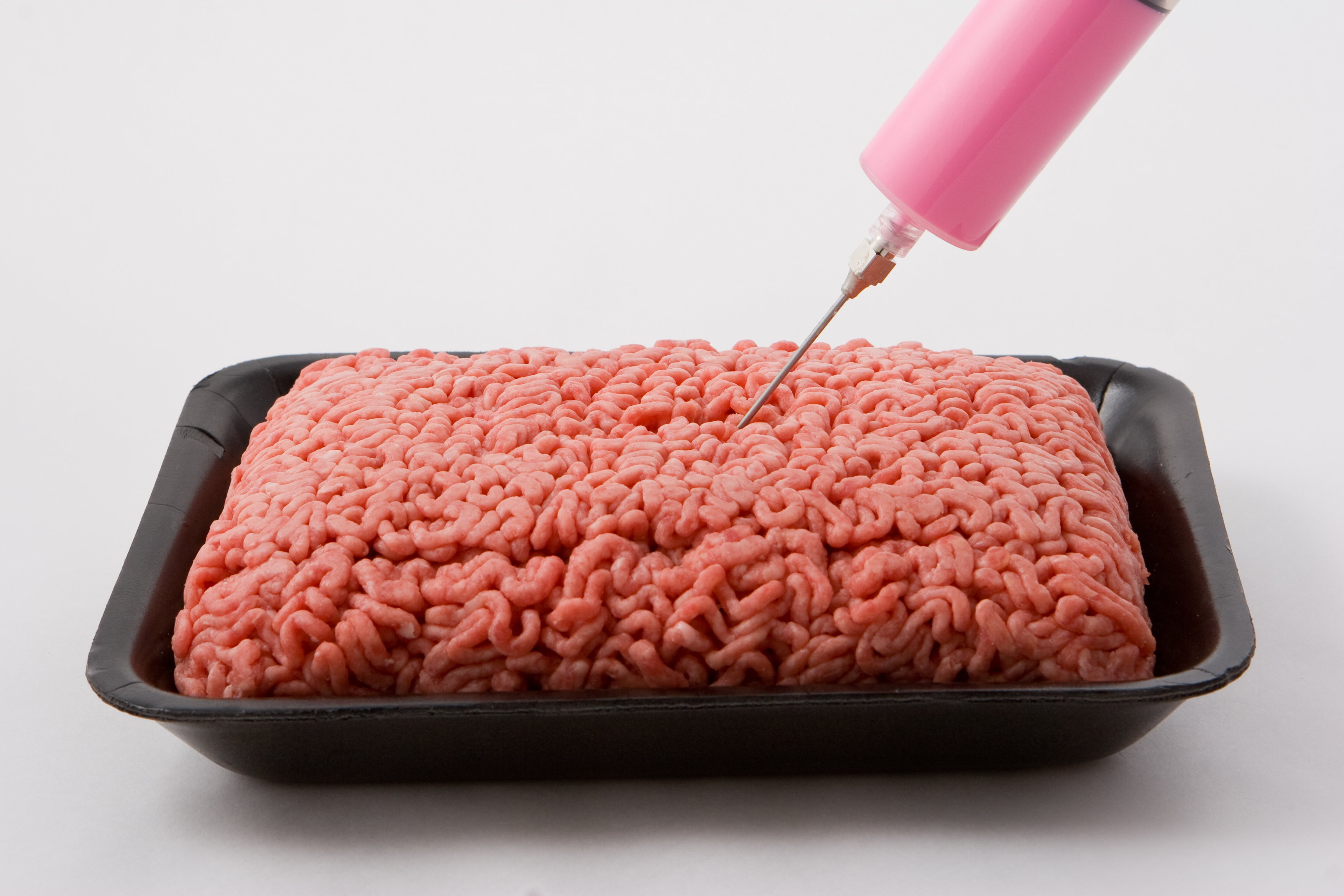Pink liquid being injected into ground beef