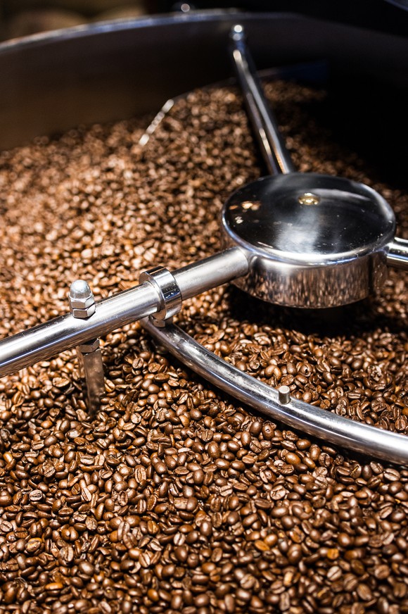 A machine mixes a vat full of coffee beans.