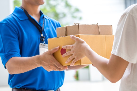 A man hands packages to someone else.