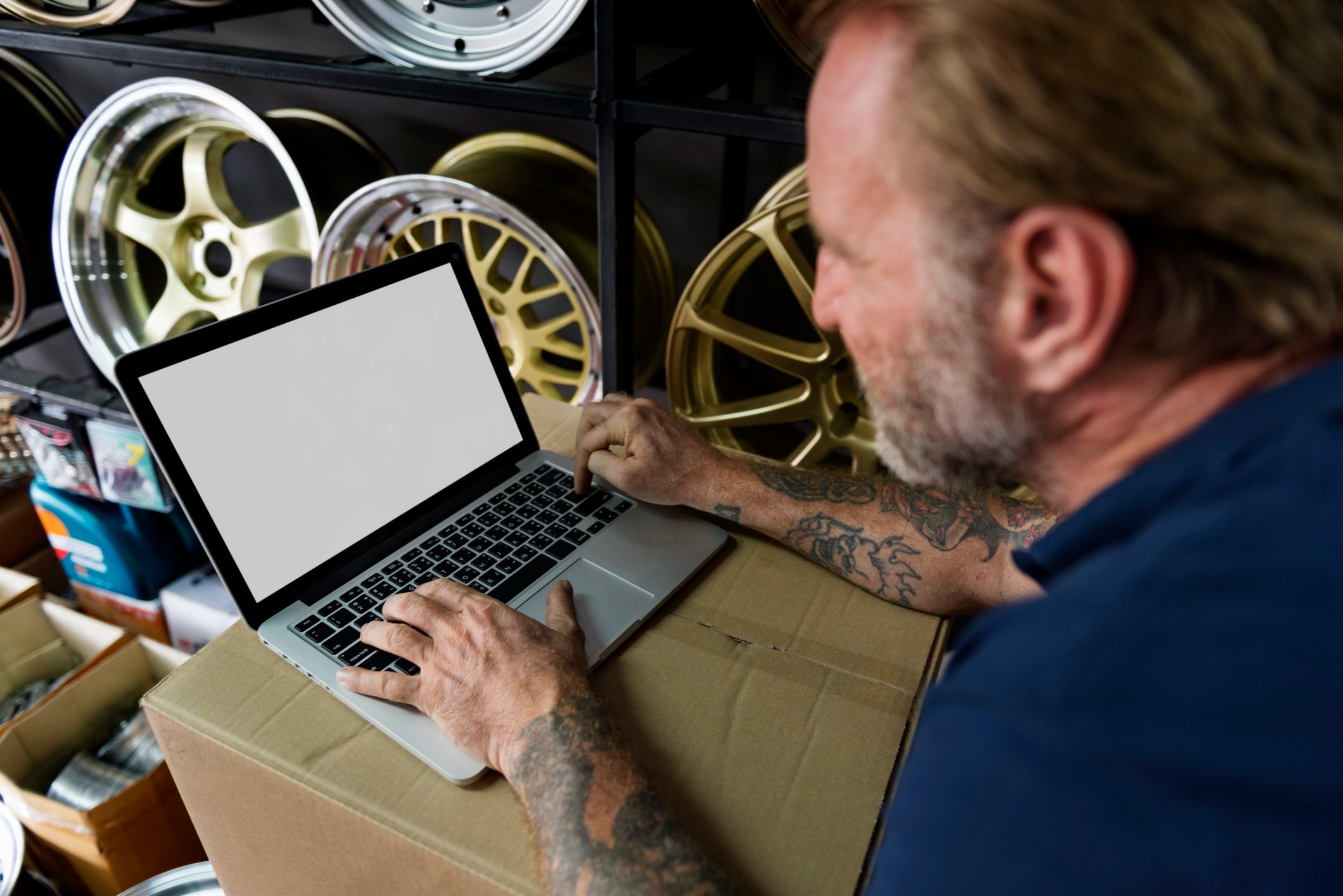 Auto retailer shop owner on a laptop