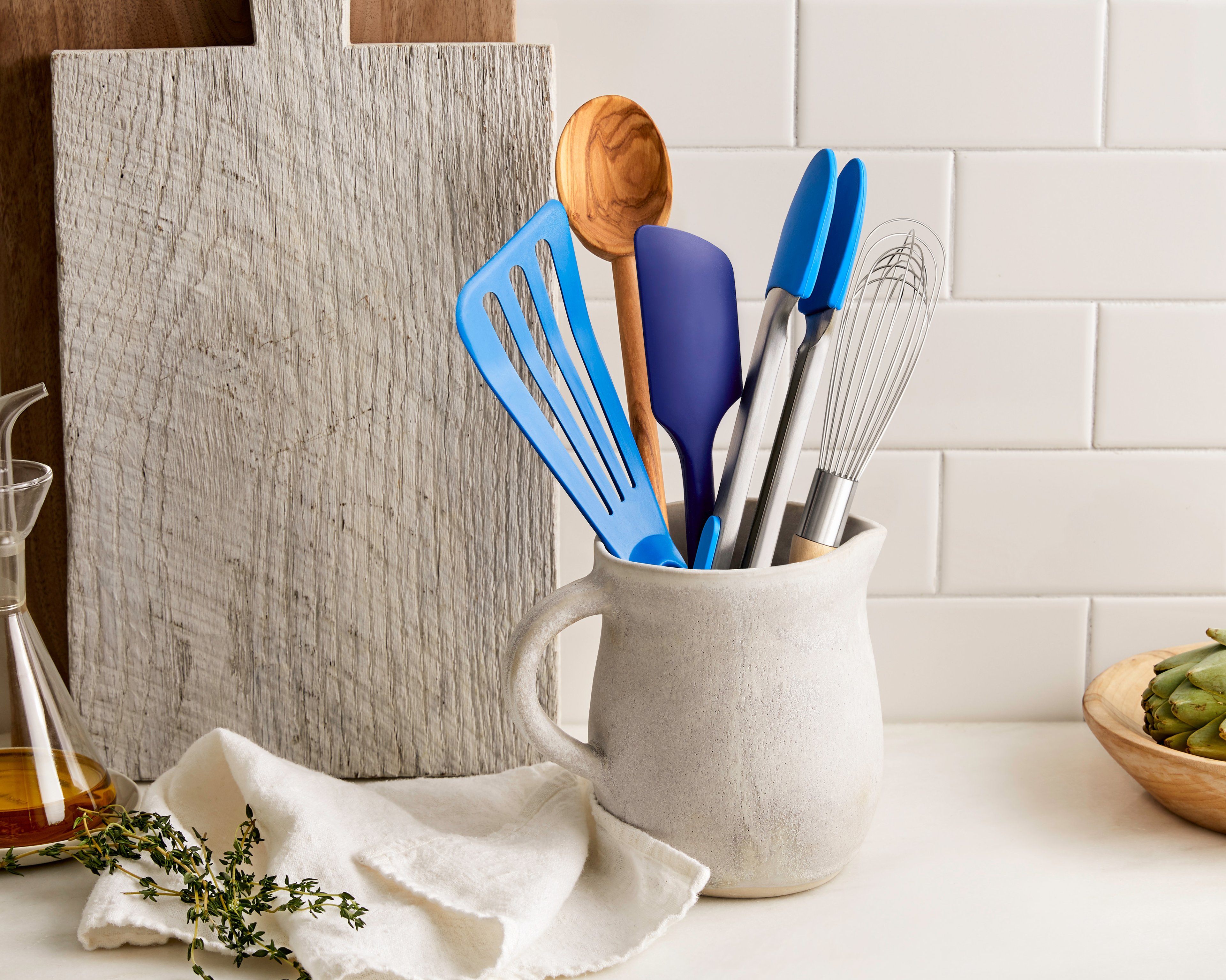 A utensil holder on a kitchen counter with spatulas and spoons