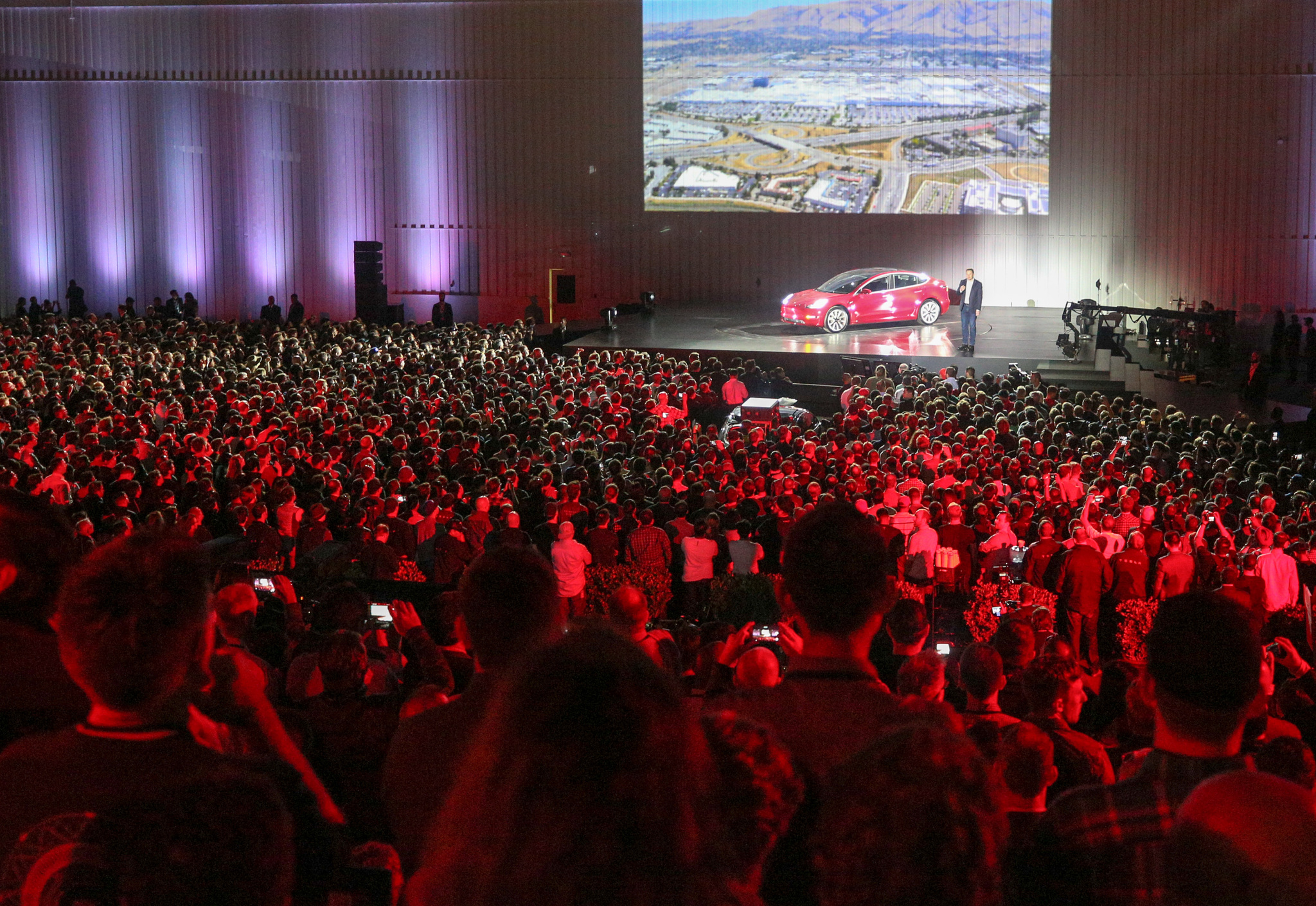 Tesla unveils the final version of its Model 3 at an event.