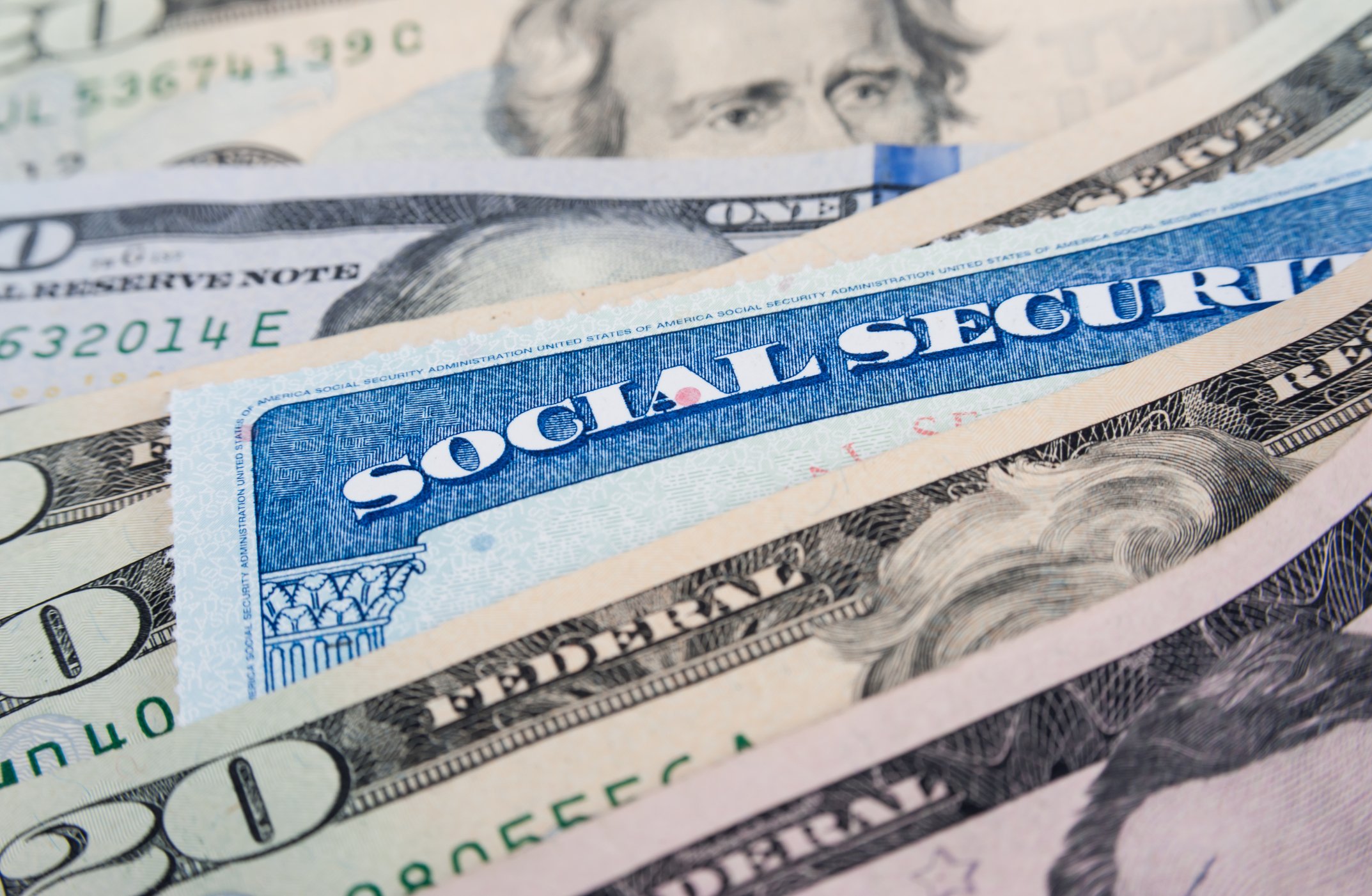 Social Security card in a pile of money.