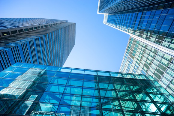 View looking up at skyscrapers into a blue sky.