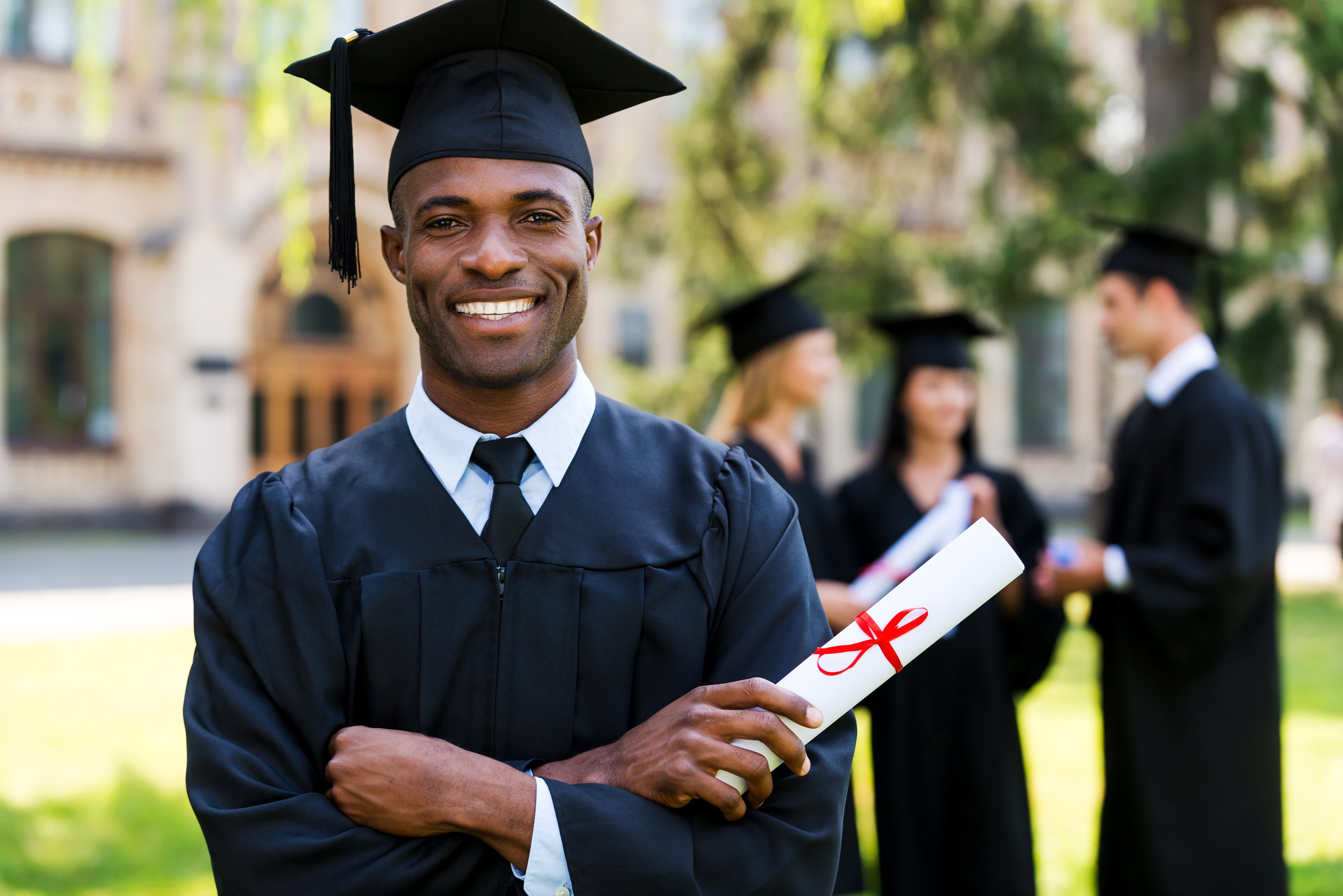 Male in cap and gown holding diploma