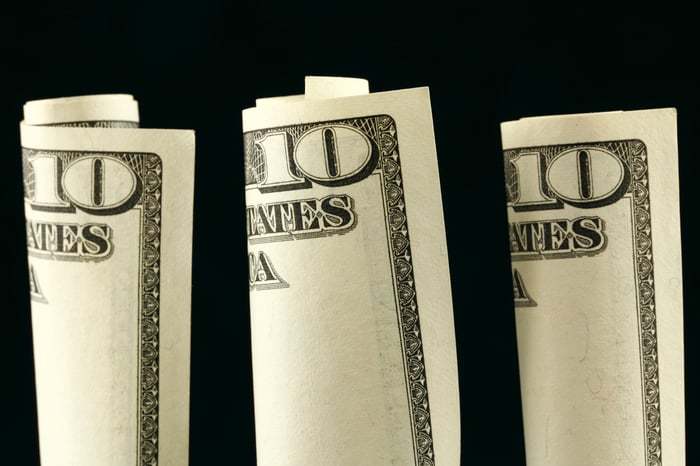 Three $10 bills rolled up 