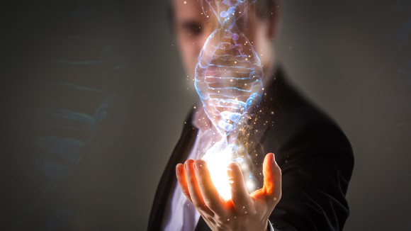 Man with hand outstretched seemingly holding a 3D image of DNA