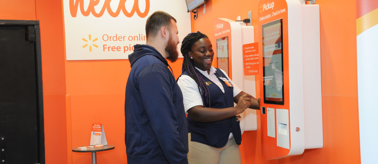 A Walmart employee helps a customer with his Pickup technology.