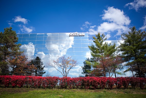 Scottrade office; glass building set behind trees and bushes.
