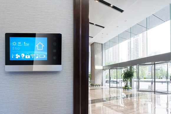 A smart home device hanging on the wall of an office lobby.