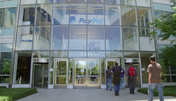 Glass paneled front building entrance with PayPal logo above door.