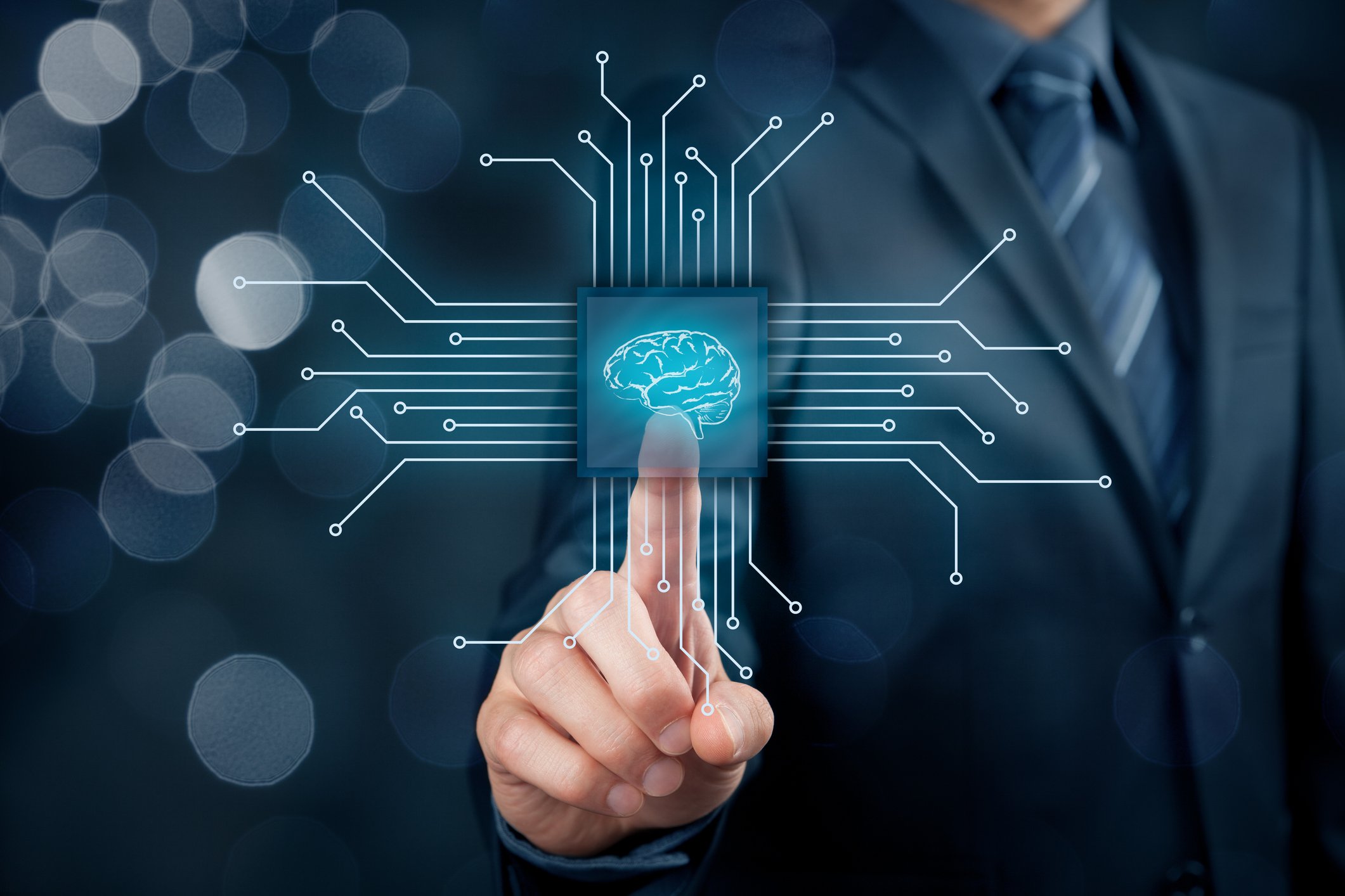 Man in business suit touching a screen with an image of a human brain. 