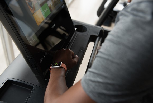 A person using an Apple Watch on a treadmill.
