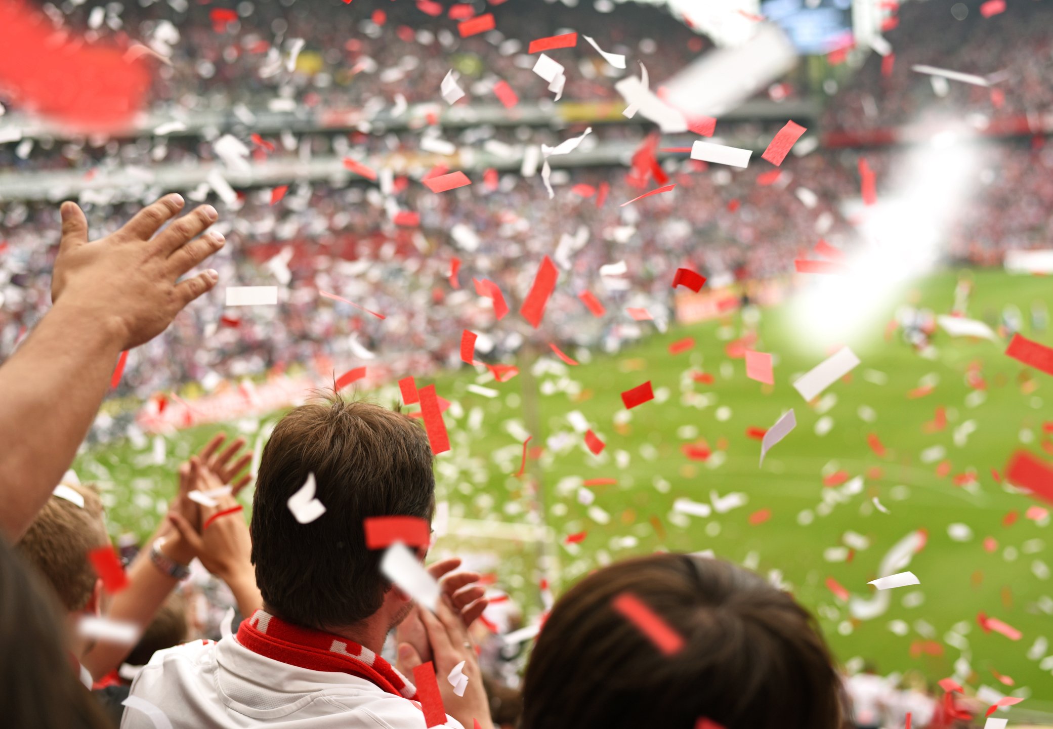 Confetti falls on the crowd at a soccer stadium.