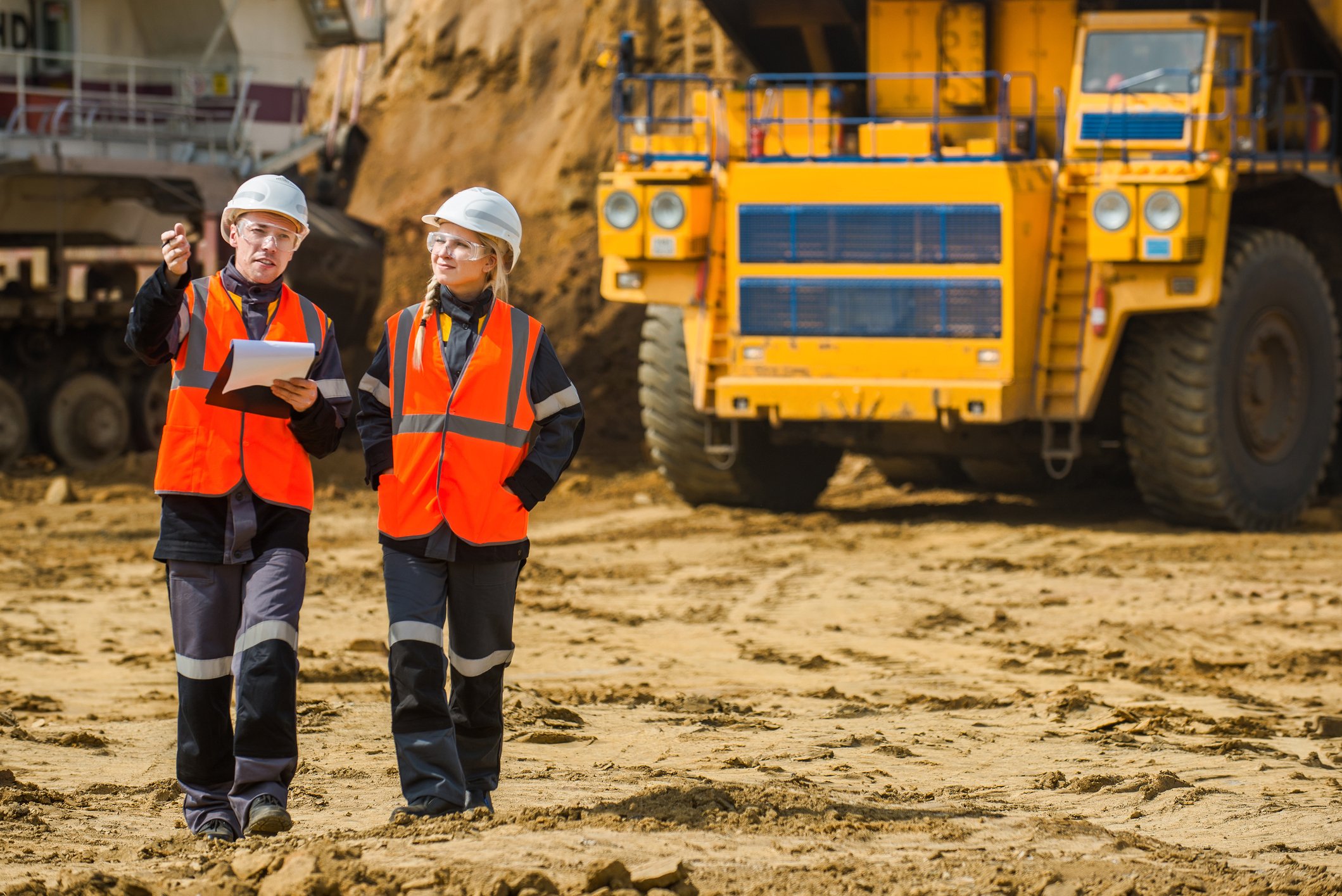 Two people are talking at a mine.