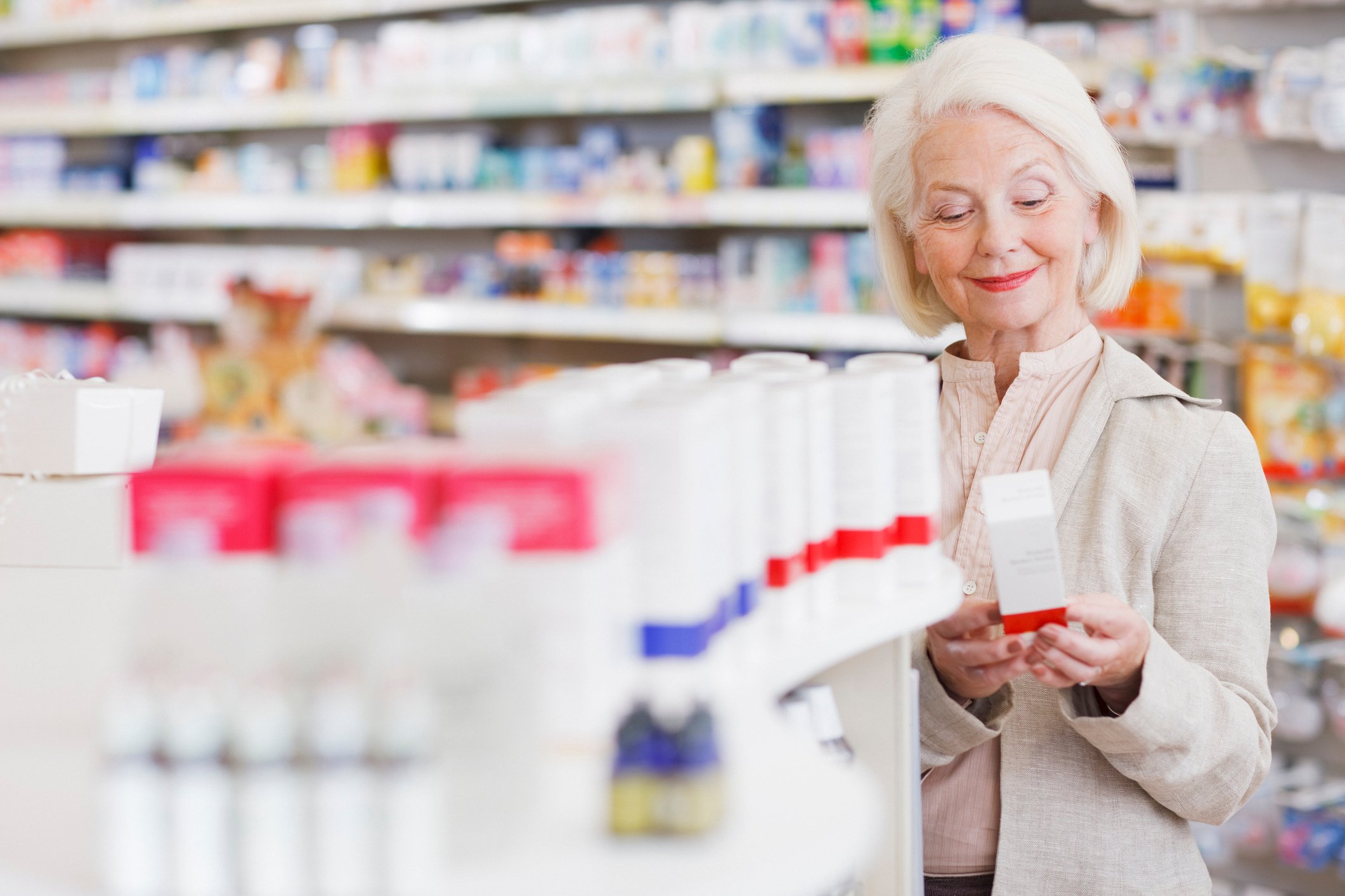 A senior woman shopping in a pharmacy store.