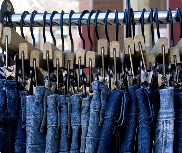 Blue jeans hanging up on a store rack