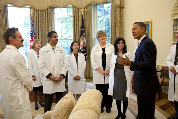 Former President Barack Obama having a discussion with doctors in the White House.