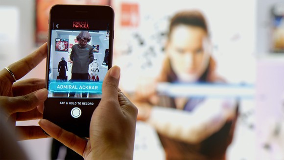 A hand holding a smartphone displaying Disney's Star Wars augmented reality app