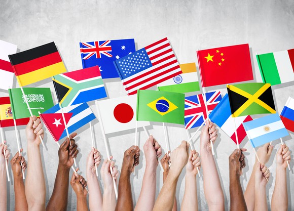 Hands holding flags of different countries.