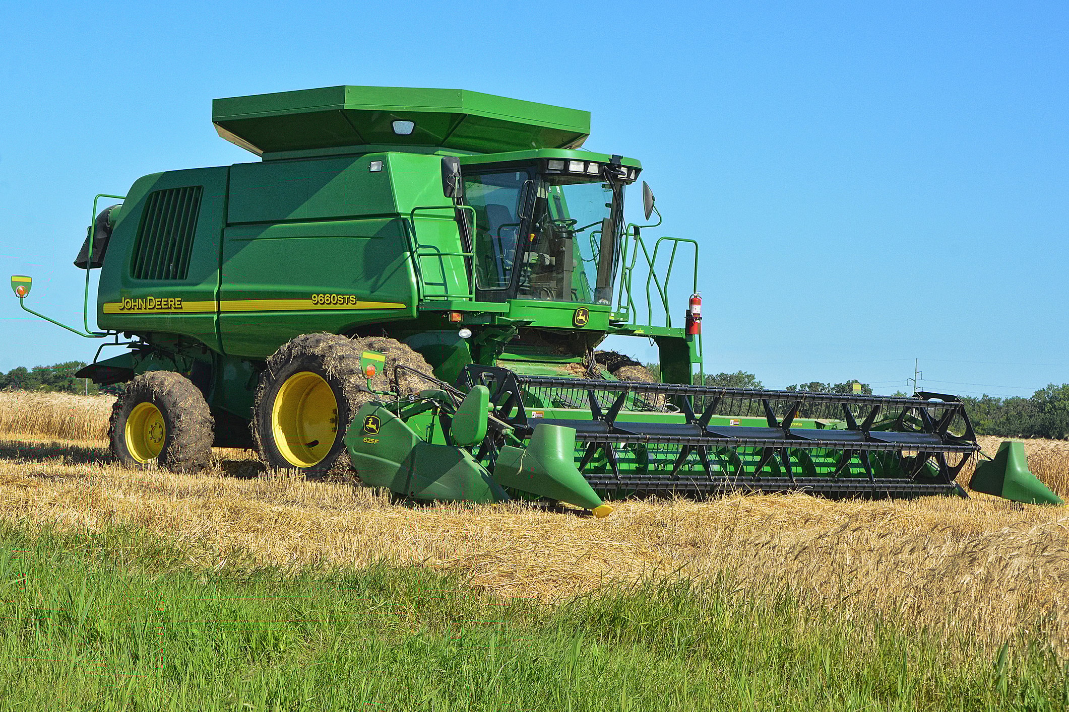 a Deere combine harvester in a field.