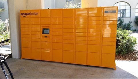 Picture of bright orange Amazon locker in a commercial shopping center courtyard.