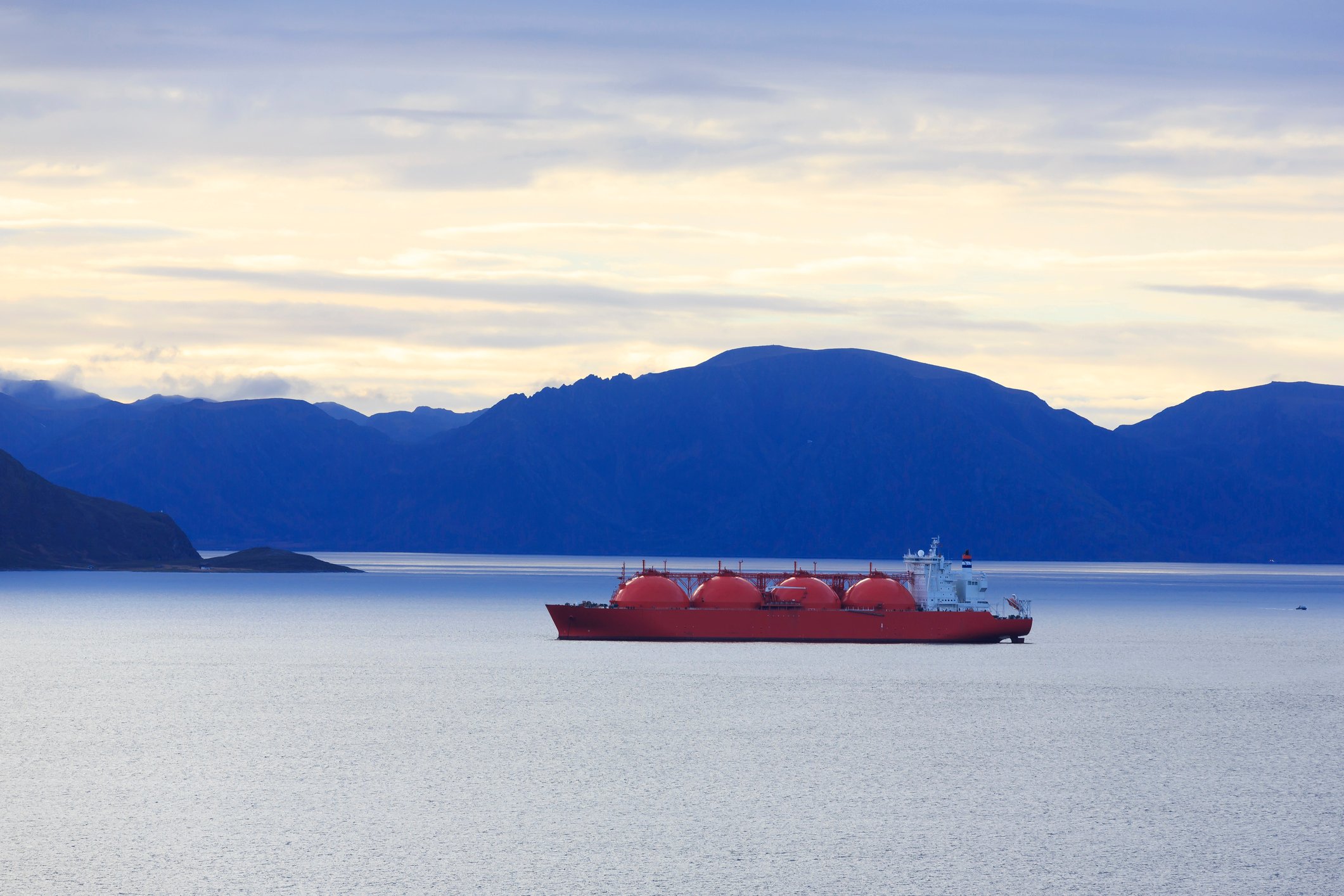 An oil tanker in Alaskan waters. Mountains are in the background.