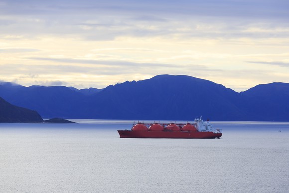 An oil tanker in Alaskan waters. Mountains are in the background.