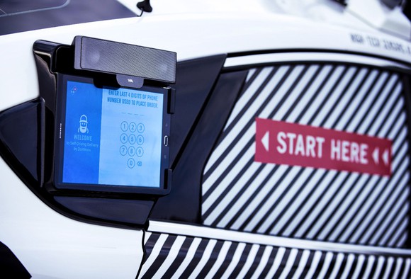 A close-up of a touchscreen on the side of the self-driving Ford Fusion Hybrid pizza-delivery test vehicle. 