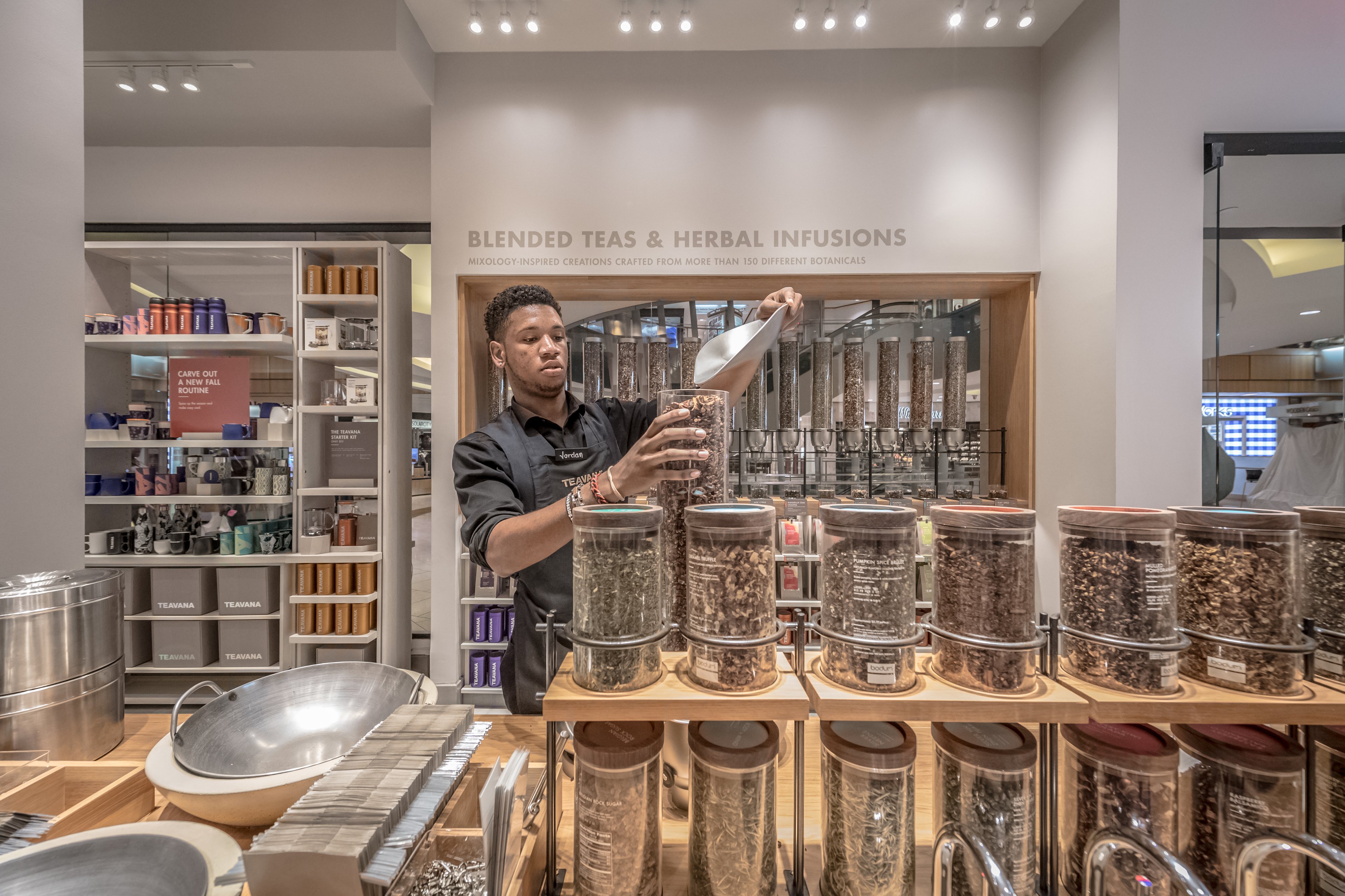 A man scoops tea at a Teavana store.