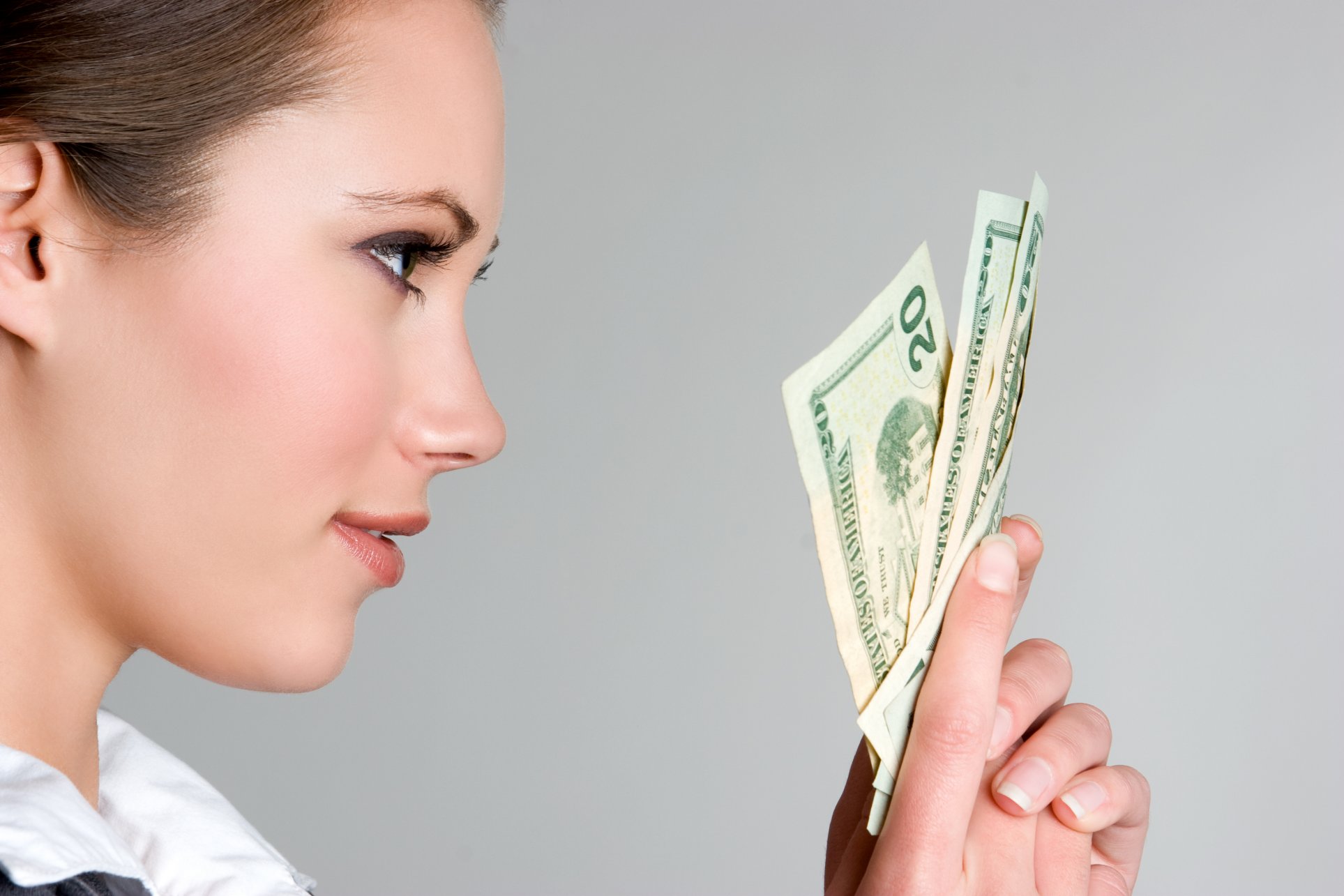 A woman holding $20 bills.