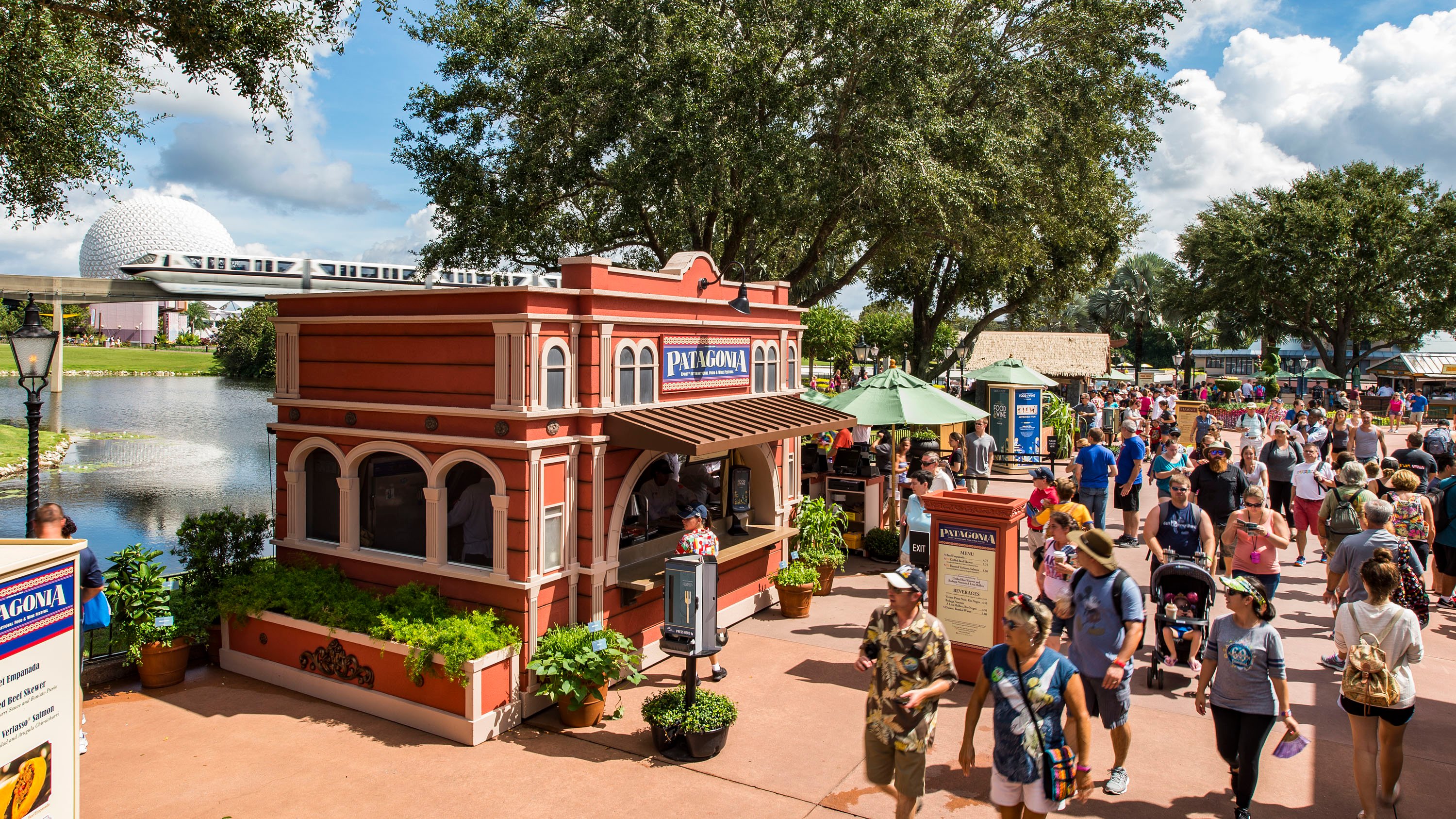 The Food & Wine Festival at Epcot with a Patagonia kiosk in front of the monorail and Spaceship Earth.