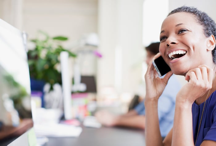 A smiling woman talking on her cellphone.