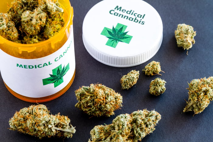 A medical cannabis prescription bottle filled with cannabis buds. 