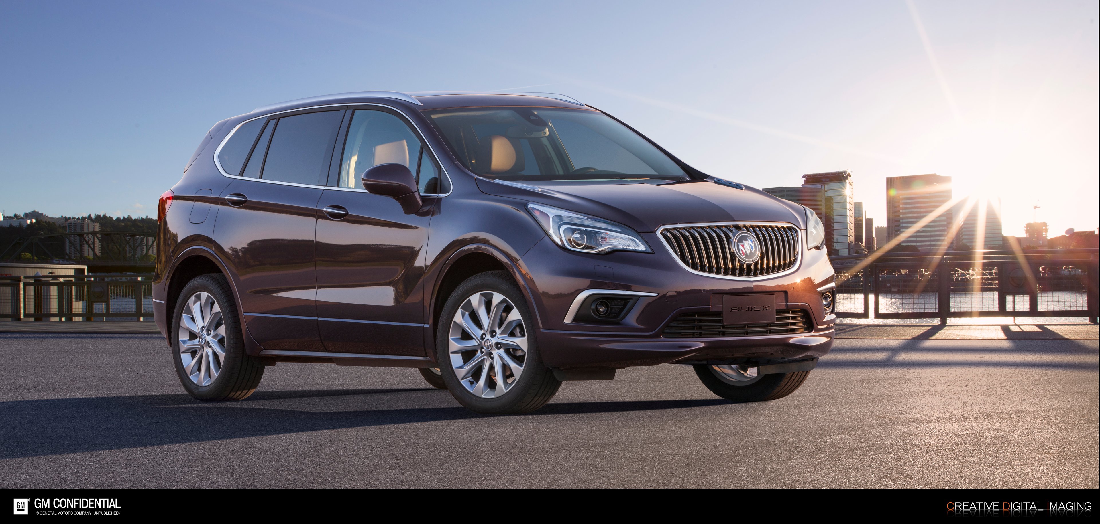 A 2017 Buick Envision with a skyline and sunset in the background. 