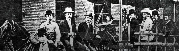 Historical picture of several people in a horse-drawn carriage with Mallinckrodt logo.