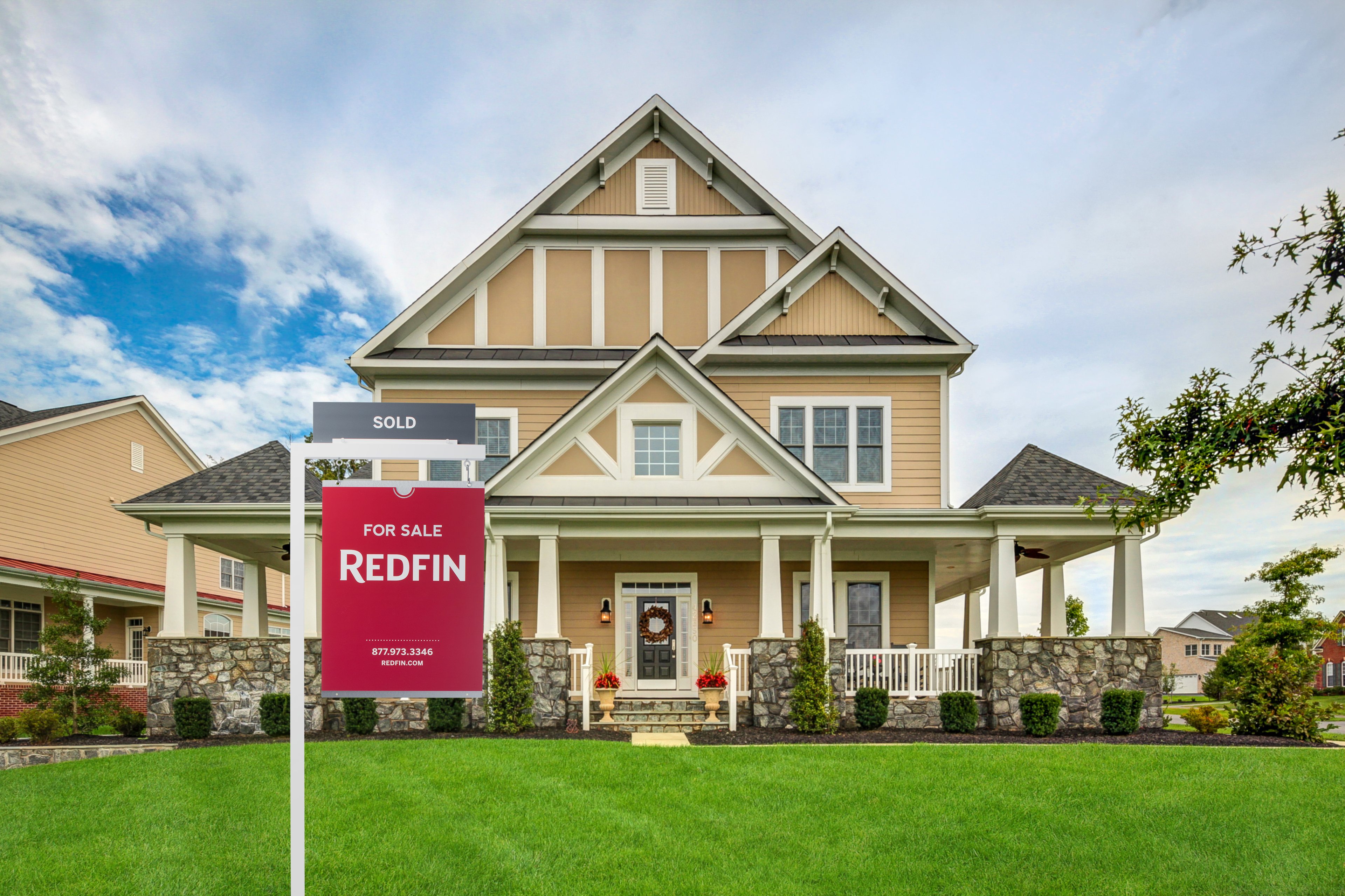A house with a "sold" Redfin sign.