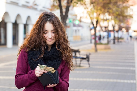 Woman pulling cash from her wallet