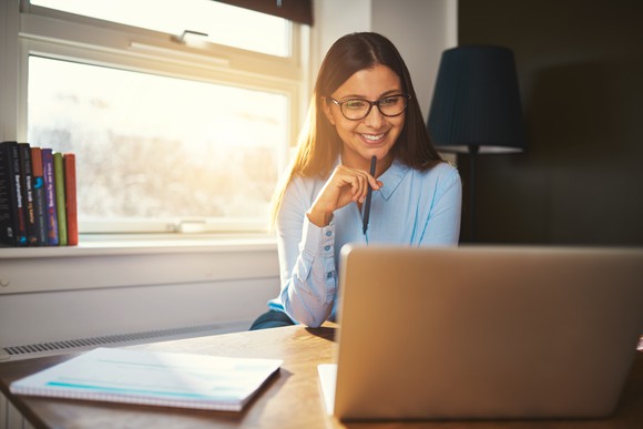 Woman with glasses looking at a laptop