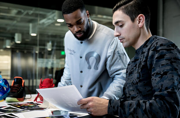 Two Under Armour employees review a document.