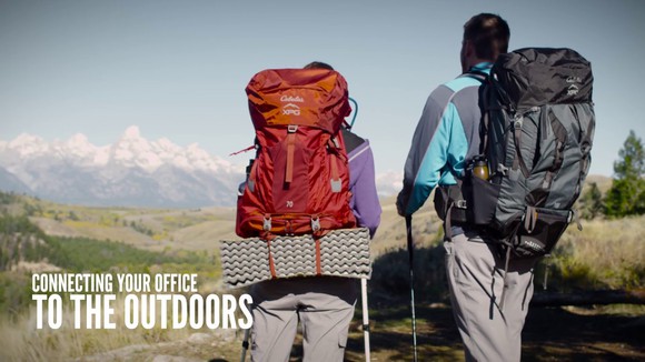 Two people with backpacks looking at a mountain range.