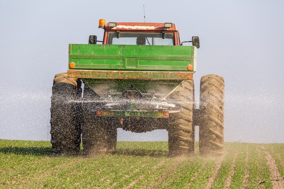 A tractor spreading fertilizer onto a field.
