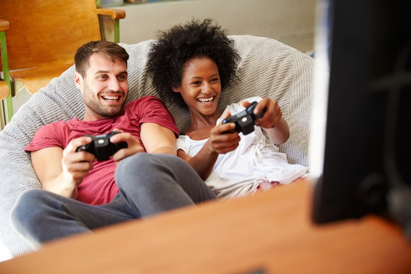 A young couple plays a video game.