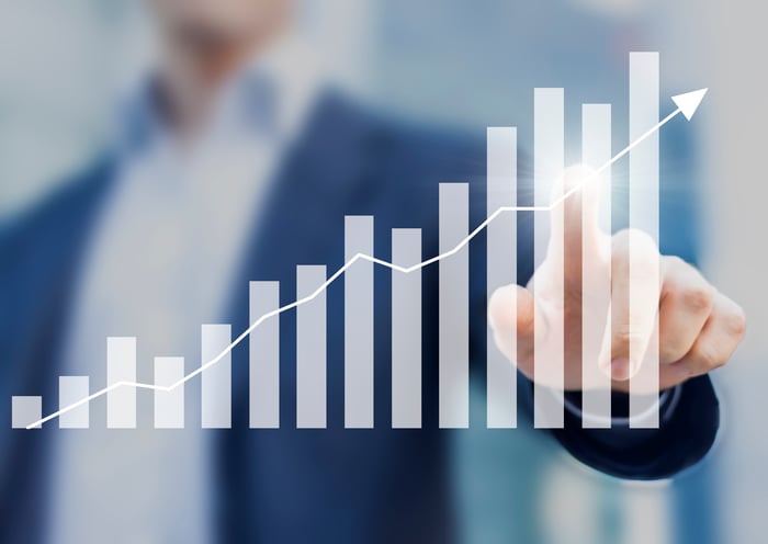 Man pointing to a bar/line chart indicating financial growth