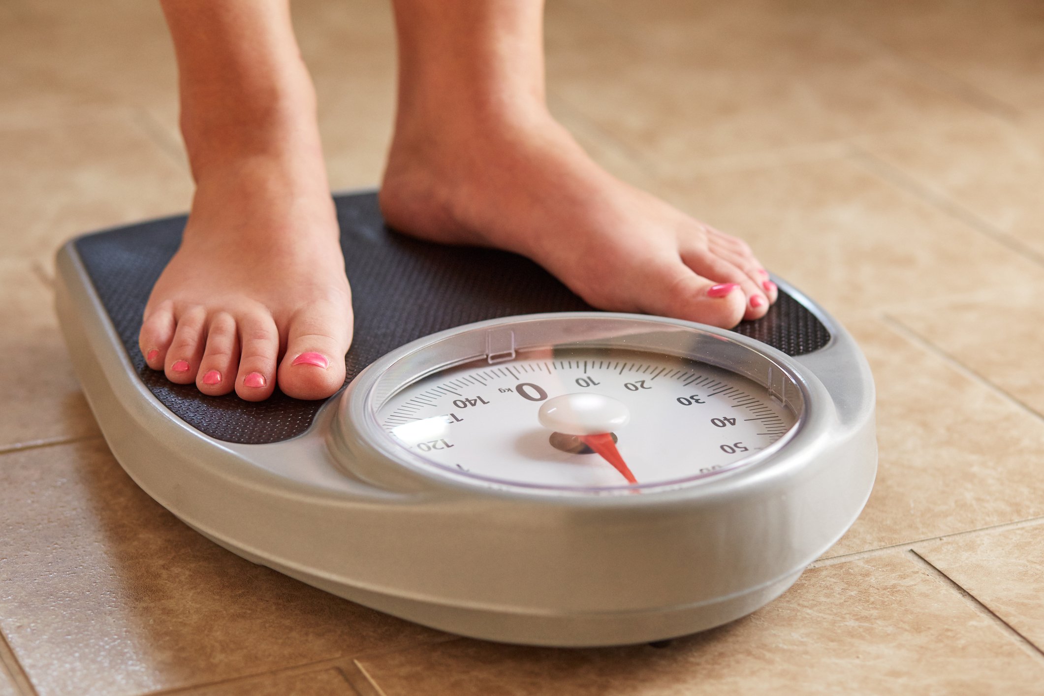 A woman standing on a scale.