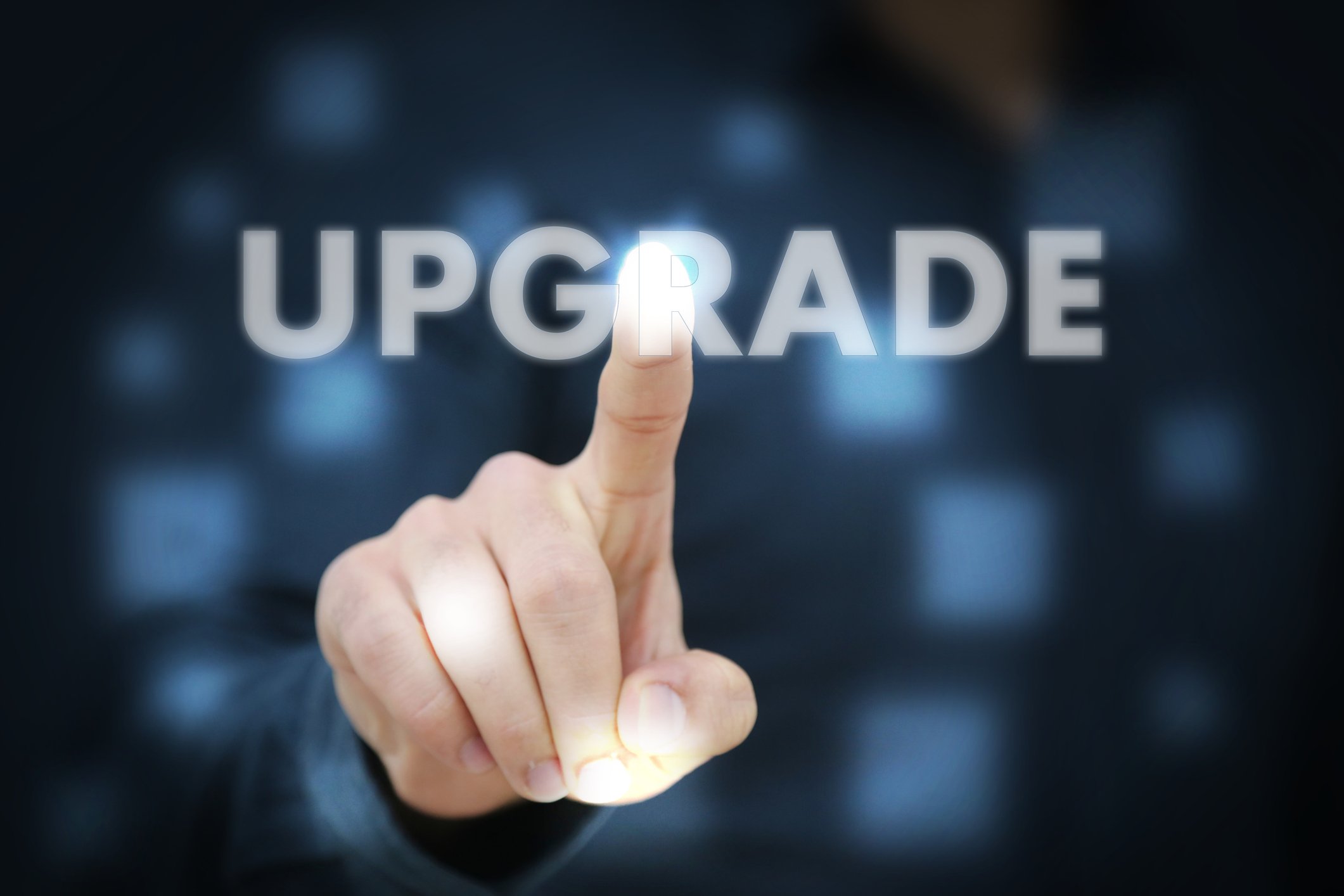 A person pointing to the word "upgrade" on a screen.