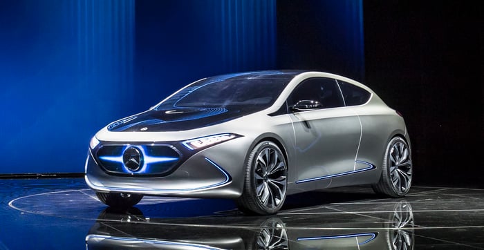 The Mercedes-Benz Concept EQA, a silver hatchback with a distinctive lighted Mercedes badge in front, on its auto-show stand in Frankfurt.