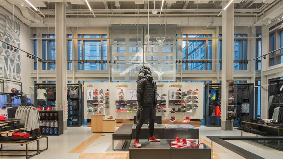 View from inside Nike's New York Soho district store, with high ceilings, lots of windows, and products prominently displayed.