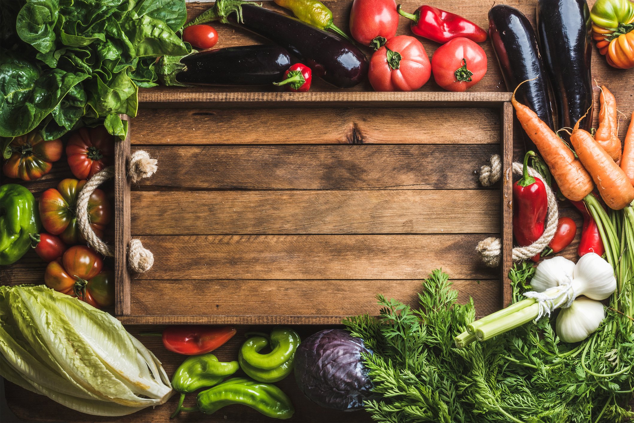 A box surrounded by a variety of vegetables.