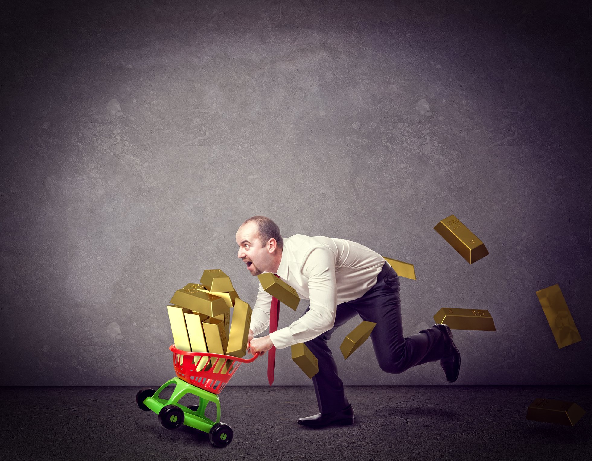 Man pushing plastic toy cart with bars of gold overflowing in basket